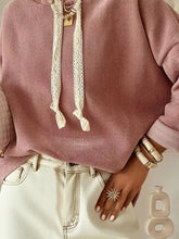 A soft pink knit drawstring dropped shoulder hoodie with white lace drawstrings and gold pendant care instructions machine wash tumble dry low