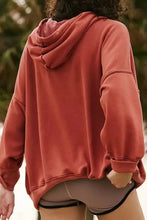 Oversized rust-colored drawstring dropped shoulder long sleeve hoodie with visible seams