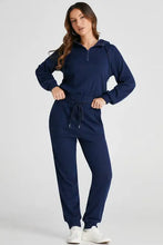 Navy blue drawstring half zip hoodie and joggers set with hood and white sneakers