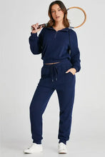 Navy blue fleece drawstring half zip hoodie and joggers set with white sneakers