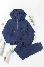 Navy blue textured drawstring half zip hoodie and joggers set with pockets, white mesh sneakers