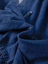 Deep indigo denim mini dress with textured weave and visible stitching featuring a high waist and puff sleeves