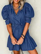 A blue denim mini dress with puff sleeves and a high waist drawstring for a stylish casual look