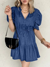 Blue denim mini dress with puffed sleeves and tiered skirt featuring a high waist drawstring detail