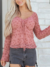 A dusty rose floral lace blouse featuring a drawstring knot detail with a ruched front and long sleeves