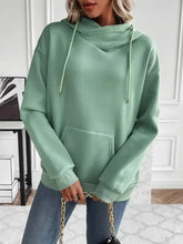 Woman in mint green long sleeve drawstring kangaroo pocket hoodie over jeans