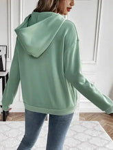 Woman in solid mint green oversized kangaroo pocket hoodie