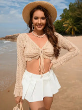 Woman in drawstring openwork long sleeve cover-up on beach