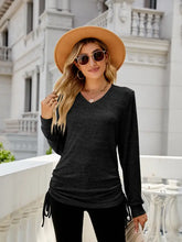 Women’s black V-neck long sleeve top with adjustable side ruching
