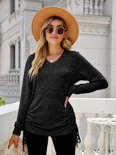 Dark grey long sleeve V-neck top with adjustable side ruching
