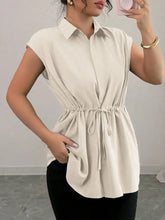 Cream-colored sleeveless drawstring waist cap sleeve blouse with button-up front and relaxed fit for casual wear
