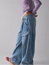 Light-wash denim cargo jeans with a relaxed wide-leg cut and elastic drawstring waist for comfortable wear