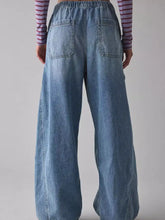 Back view of light-wash denim drawstring waist cargo jeans with wide-leg fit elastic waistband and two back pockets