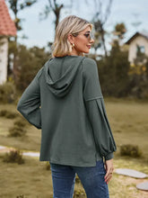 Woman in dropped shoulder hoodie with long sleeve length and relaxed fit