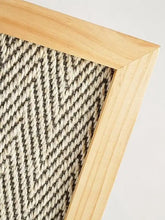 Durable vertical sisal cat scratcher with light wood-framed herringbone rug