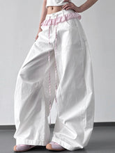 White wide leg drawstring casual pants with pink ruffled waistband and matching drawstring for comfortable wear