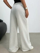 Light gray wide leg drawstring sweatpants with soft texture and elastic waistband featuring easy care instructions