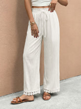 White wide leg trousers with drawstring waist and delicate lace trim wide hem for elegant casual wear