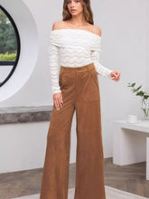 Brown suede high-waisted wide-leg pants featuring front pockets and care instructions for easy maintenance