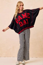 Black oversized sweatshirt with bold red game day lettering and trim paired with bibi gameday checkered printed pants