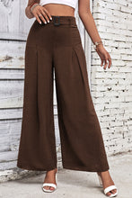 High waisted wide leg brown trousers with pleated front and black belt buckle in wide leg pants style