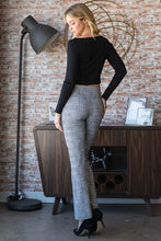 A woman wearing heimish plus size plaid flare pants with wide waistband paired with a black cropped long sleeve top