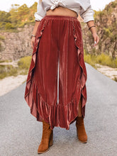 Plus size velvet wide-leg pants in rust color with layered ruffle hem detailing and soft velvet fabric