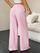 Soft pink tied wide leg pants with wide leg cut, relaxed fit, and subtle vertical pleats for stylish comfort