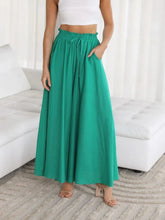 Emerald green high-waisted wide leg pants with drawstring waist and side pockets in maxi skirt style
