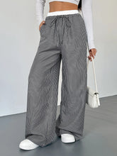 Black and white striped wide leg drawstring pants with a comfortable waistband for casual or lounge wear