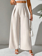 Cream-colored wide leg high waist trousers with pleated design in smooth fabric for elegant office wear