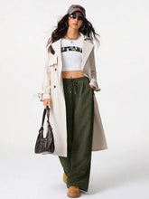 Black leather hobo bag with structured shape and top handle paired with relaxed fit corduroy pants with drawstring