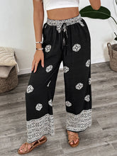 Black wide leg pants with white geometric embroidery and lace trim at waistband and hem boho print wide leg pants