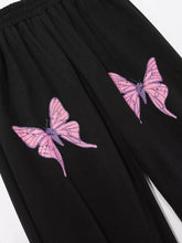 Black butterfly casual sweatpants with two pink butterfly prints outlined in purple and speckled details for casual wear