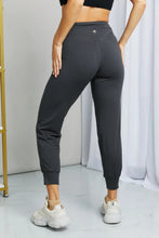 Dark gray cropped joggers from leggings depot with wide waistband, stretchy fabric, and elastic cuffs in high-waisted fit