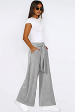 Gray tied pocketed wide leg pants with a tied waistband and side pockets in a comfortable wide leg style
