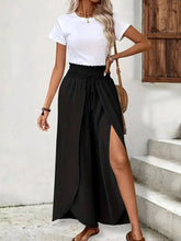 Black high-waisted side slit pants in polyester fabric with drawstring waist, suitable for machine wash care instructions