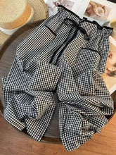 Black and white gingham pattern high-waisted wide-leg pants with elastic drawstring waistband and gingham pants design