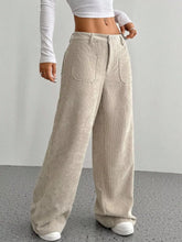 Beige wide leg corduroy pants with front pockets and a relaxed fit made from soft corduroy fabric