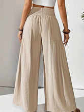 Beige smocked waist wide leg trousers with subtle pleats and a comfortable smocked waistband for versatile wear