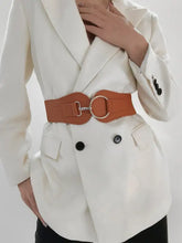 Woman in white blazer with elastic wide belt and gold O-ring buckle