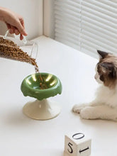 Elevated ceramic pet bowl with green cat design, white pedestal, scalloped rim