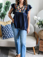 Navy blue blouse with colorful floral ruffle sleeve embroidery and ruffled sleeves for a stylish look