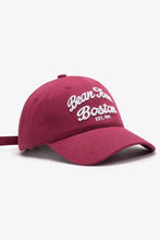 Maroon embroidered graphic baseball cap with white text