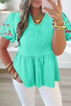 A vibrant mint green textured blouse with puff sleeves featuring colorful embroidered butterflies