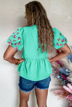 Mint green embroidered puff sleeve top with textured fabric showcasing intricate sleeve detailing and elegant design