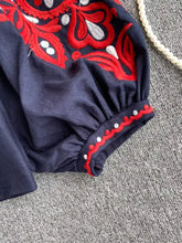 Navy blue embroidered tassel tie neck blouse with intricate red and white floral embroidery on the sleeve cuff
