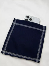 Navy blue fabric phone pocket with white zigzag stitching detail on exposed seam color block patch pocket sweatshirt machine wash cold