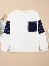 White sweatshirt with navy striped sleeves and patch pocket featuring exposed seam detail and contrasting white stitching, machine wash cold