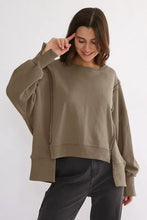 Women’s olive green exposed seam long sleeve sweatshirt with asymmetrical hem